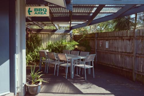 a patio with a table and chairs under a pergola at Culburra Beach Motel in Culburra Beach