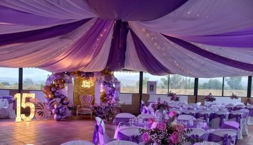 une tente violette et blanche avec des tables et des chaises dans l'établissement La Martina Campestre, à Sutamarchán