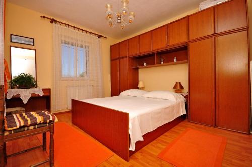 a bedroom with a large bed and a chandelier at Apartments Kat in Splitska