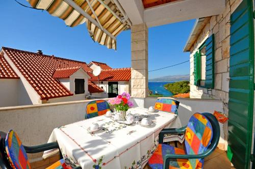 a table on a balcony with a view of the water at Apartments Kat in Splitska