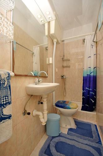 a bathroom with a sink and a toilet at Apartments Kat in Splitska