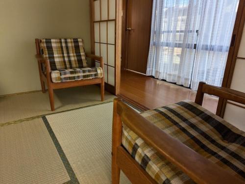 a living room with a chair and a chair at Tsubame Sanjo Local Stay KYU in Sanjo