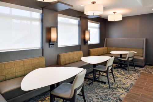 a waiting room with tables and chairs and windows at Residence Inn by Marriott Bakersfield West in Bakersfield