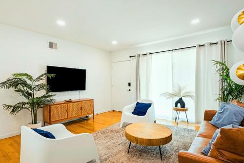 a living room with a couch and a tv at Spacious 3BR Home Near Disneyland & Knotts Berry Farm in Fullerton