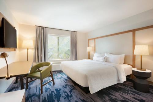 a hotel room with a bed and a desk and a window at Fairfield Inn & Suites by Marriott Boulder Longmont in Longmont
