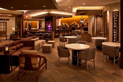 a restaurant with tables and chairs and a bar at Denver Marriott West in Golden
