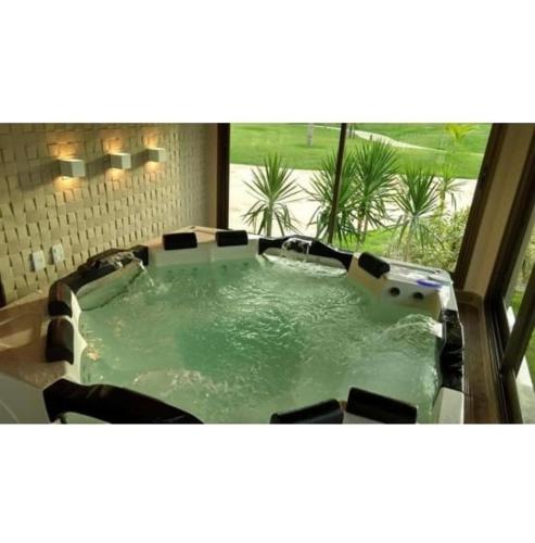 a jacuzzi tub in a bathroom with a window at VG Sun Cumbuco by TP Flats in Cumbuco