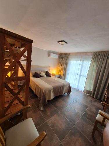 a bedroom with a large bed and a large window at Mirada al Champaqui - Departamento de Montaña in Villa Yacanto
