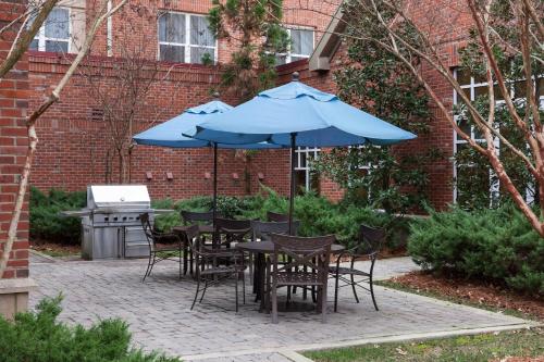 a patio with tables and chairs with blue umbrellas at Residence Inn by Marriott Franklin Cool Springs in Franklin