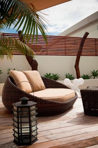 a wicker rattan chair sitting on a patio at Le Méridien Nouméa Resort & Spa in Noumea