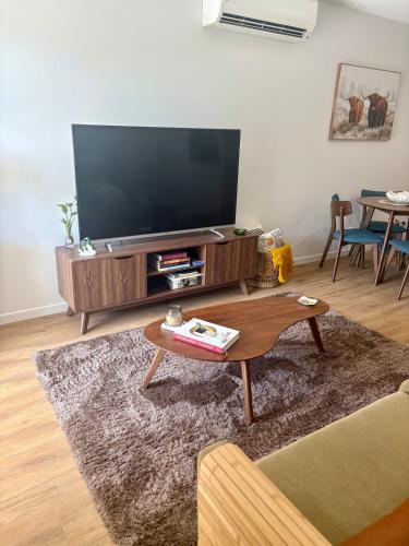 a living room with a television and a coffee table at Chermside Central Apartment in Brisbane