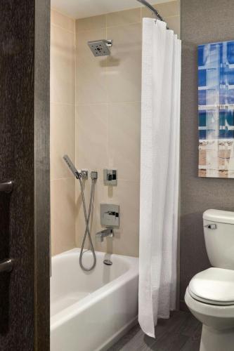 a bathroom with a white tub and a toilet at Ventura Beach Marriott in Ventura