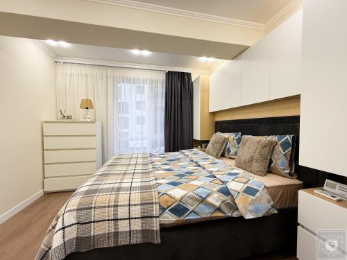 a bedroom with a bed and a dresser at RentHouse Apartments Diplomat in Chişinău