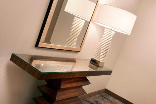 a glass table with a lamp and a mirror at Detroit Metro Airport Marriott in Romulus