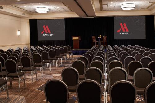 a conference room with chairs and a podium at Detroit Metro Airport Marriott in Romulus