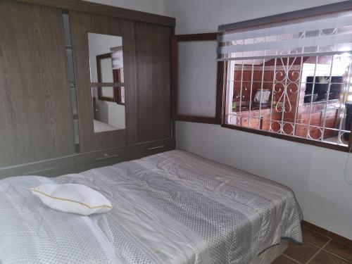 a bedroom with a bed and a window with a mirror at Colinas in Ciudad de la Costa