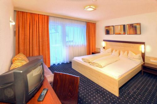 a hotel room with a bed and a tv at A Casa Kristall in Sölden