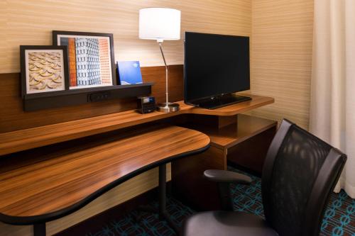 a desk with a computer monitor and a chair at Fairfield Inn & Suites by Marriott Utica in Utica