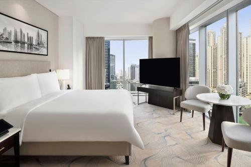 a hotel room with a bed and a flat screen tv at JW Marriott Hotel Marina in Dubai