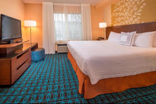 フレデリックにあるFairfield Inn & Suites by Marriott Frederickのベッドと薄型テレビがあるホテルの部屋