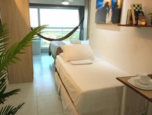 a bedroom with two beds and a large window at Terras Studio Fortaleza Sul in Fortaleza