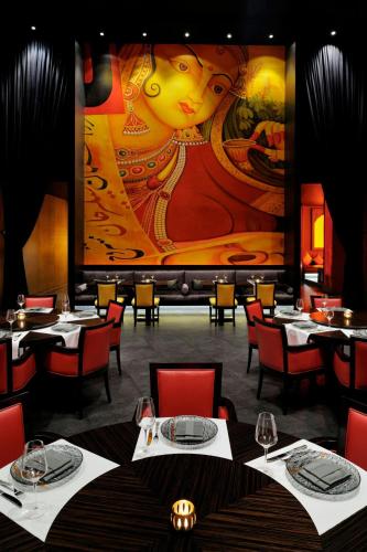 a restaurant with tables and a large painting on the wall at JW Marriott Marquis Hotel Dubai in Dubai