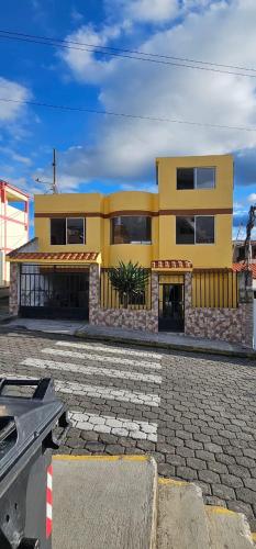 a large yellow building with aphalt at Departamentos La Frontera in Tulcán