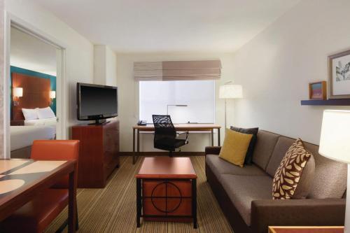 a living room with a couch and a tv at Residence Inn Bismarck North in Bismarck