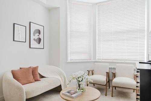 a living room with a couch and two chairs and a table at Cosy Charming Apartment in Central London in London