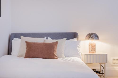 a bedroom with a white bed with white pillows at Cosy Charming Apartment in Central London in London