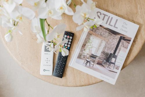 a table with two remote controls and a magazine at Cosy Charming Apartment in Central London in London