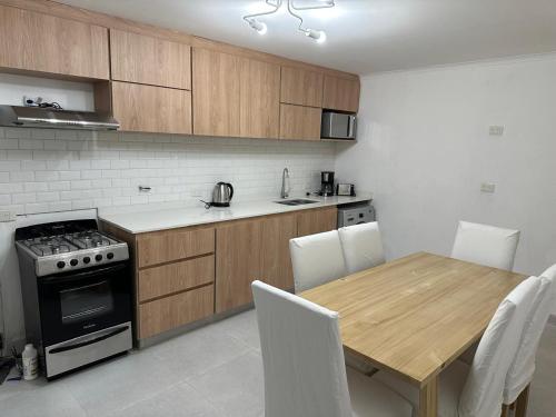a kitchen with a wooden table and a table and chairs at Casa a Estrenar - Monte Hermoso in Monte Hermoso