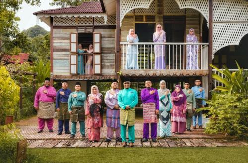 a group of people standing in front of a house at Bagas Zakariah Orchard Lodge in Gopeng