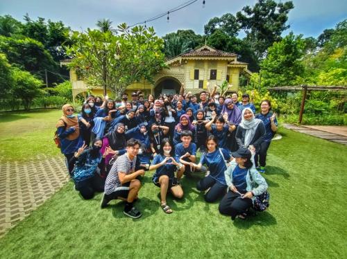 a group of people posing for a picture in front of a house at Bagas Zakariah Orchard Lodge in Gopeng