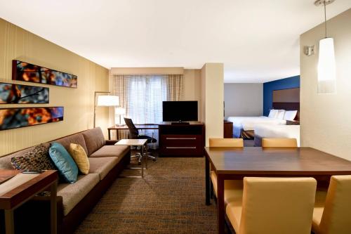 a hotel room with a couch and a bed at Residence Inn by Marriott Springfield Chicopee in Chicopee