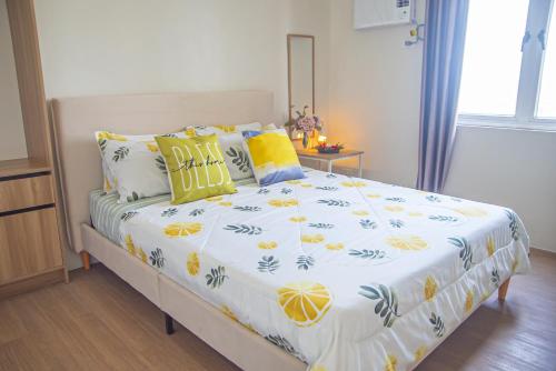a bedroom with a bed with yellow pillows at CDO Spacious 1 BR Corner Condo in front of Limketkai Mall in Cagayan de Oro