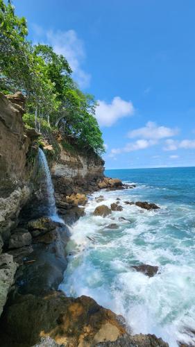 a waterfall on a cliff next to the ocean at Sunny 2-bed condo - fast WIFI in Puntarenas