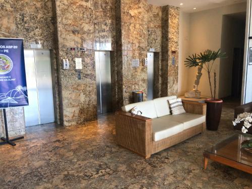 a living room with a couch in a room with stone walls at Suite Vista al mar in Natal
