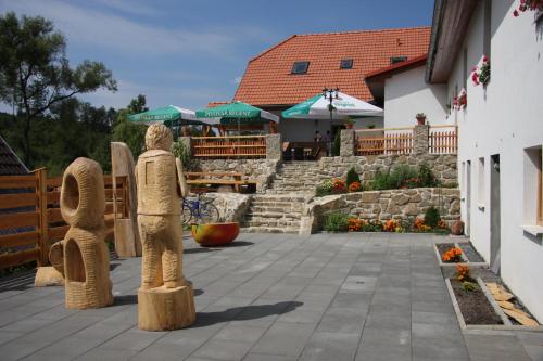 two statues of people standing on a patio at Penzion U Černého Potoka in Nová Lhota