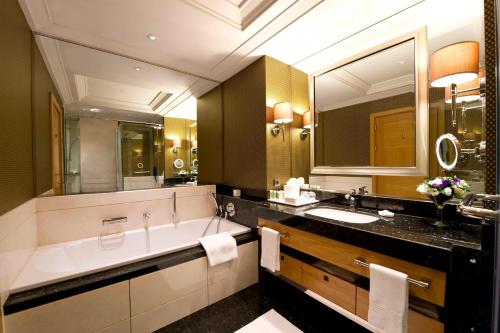 a bathroom with a large tub and a large mirror at JW Marriott Hotel Ankara in Ankara