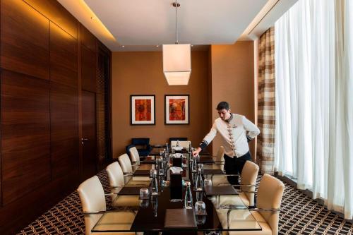 a man is standing in front of a long table at JW Marriott Hotel Ankara in Ankara