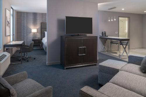 a hotel room with a couch and a television at Residence Inn Boston Downtown/South End in Boston