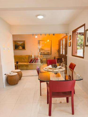 a living room with a glass table and chairs at Casa com jacuzzi piscina e comodidade a beira mar in Maragogi