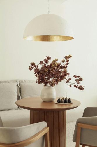 a vase of flowers on a table in a living room at Domes Miramare, a Luxury Collection Resort, Corfu - Adults Only in Moraitika