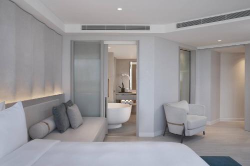 a bedroom with a bed and a chair and a bathroom at JW Marriott Gold Coast Resort & Spa in Gold Coast