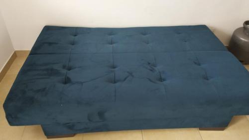 a blue bed sitting on the floor in a room at apartment 1 bedroom in Mongaguá