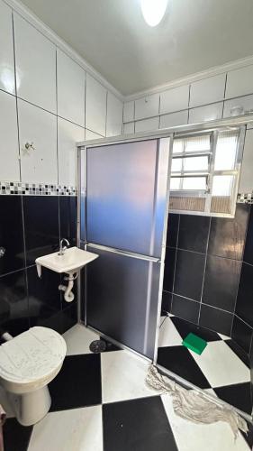 a bathroom with a toilet and a sink at apartment 1 bedroom in Mongaguá
