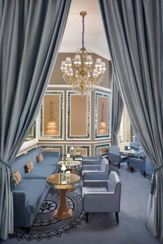 a living room with blue couches and a chandelier at Hotel Maria Cristina, a Luxury Collection Hotel, San Sebastian in Donostia-San Sebastián
