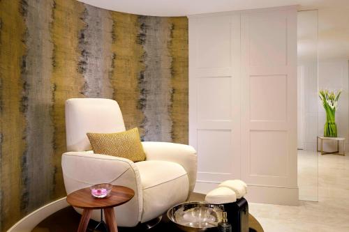 a living room with a white chair and a table at The Alexander, a Luxury Collection Hotel, Yerevan in Yerevan