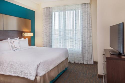 a hotel room with a bed and a large window at Residence Inn by Marriott Boston Braintree in Braintree